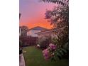 Charming backyard features a lush lawn, flowering tree, and well-maintained landscaping at sunset at 6575 Eli Davis Rd, Cumming, GA 30040