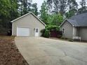 Detached garage with a concrete driveway in a wooded setting at 125 Murphy Creek Ln, Fayetteville, GA 30215