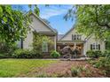 Charming home showcasing lush landscaping, stone accents, and inviting front porch under a bright blue sky at 1495 Old Hunters Lake Dr, Marietta, GA 30062