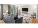 Bright living room with hardwood flooring, balcony access, modern decor, and a comfortable sofa at 6851 Roswell Rd # H12, Atlanta, GA 30328