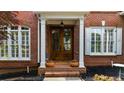 Inviting front entrance with a wooden double door, white columns, and manicured flower beds at 2135 Glenfield Trce, Cumming, GA 30041