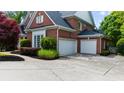Spacious three-car garage with an extensive driveway and well-maintained landscaping at 2135 Glenfield Trce, Cumming, GA 30041