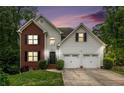 Charming two-story home with a brick accent, attached two car garage, and a well-manicured lawn at 3073 Hopeland Dr, Powder Springs, GA 30127