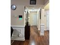 Hallway with hardwood floors, wainscoting, neutral walls, and access to multiple rooms at 133 Titan Rd, Stockbridge, GA 30281