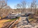 Exterior view of gray two-story home on a hill with covered parking and lake view at 405 Miller Rd, Covington, GA 30014