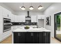 Modern kitchen with white cabinets, a black island with marble countertop, and stainless steel appliances at 223 Altoona Sw Pl, Atlanta, GA 30314