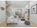Cozy living room featuring light hardwood floors, a comfortable white sofa, and stylish decor at 223 Altoona Sw Pl, Atlanta, GA 30314