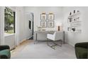 Bright home office with natural light, neutral decor, a desk, a white chair, and stylish shelving at 223 Altoona Sw Pl, Atlanta, GA 30314