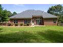 Spacious backyard with a well-maintained lawn, brick exterior, and an inviting patio area at 240 Huiet Dr, Mcdonough, GA 30252