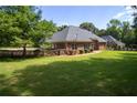 Expansive backyard with lush green grass, a privacy fence, and mature trees creating a serene setting at 240 Huiet Dr, Mcdonough, GA 30252