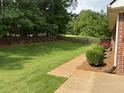 Enjoy a large, fenced backyard with lush green grass and a charming patio area at 240 Huiet Dr, Mcdonough, GA 30252