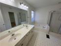 Bathroom featuring dual sinks, a soaking tub, and a glass-enclosed shower at 2887 Royal Blf, Decatur, GA 30030
