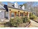 Charming brick home with wood-stained columns, shuttered windows, and manicured landscaping at 950 Besse Way, Locust Grove, GA 30248