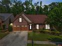 Charming brick home with well-manicured landscaping and a two-car garage at 1867 Willoughby Dr, Buford, GA 30519