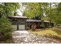 This lovely home features a two-car garage, inviting red deck, and charming curb appeal at 633 Iris Rd, Pine Lake, GA 30072