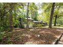 View of the side of the home, showing the wood exterior surrounded by mature trees at 633 Iris Rd, Pine Lake, GA 30072