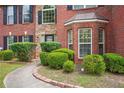 Close up view of a brick home's front yard with manicured bushes and a curved walkway at 9744 Musket Ridge Cir, Jonesboro, GA 30238