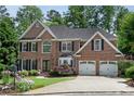 Beautiful brick two-story home featuring a manicured lawn, mature landscaping, and a two-car garage at 3106 Soldier Trl, Marietta, GA 30068