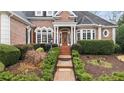 Charming brick walkway leads to the front door with lush landscaping at 5560 Stoneleigh Dr, Suwanee, GA 30024