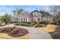 Stately brick home with manicured landscaping and a circular driveway at 5560 Stoneleigh Dr, Suwanee, GA 30024