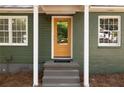 Close-up of a welcoming front entrance with an eye-catching yellow door and white window frames at 720 Maynard Se Ter, Atlanta, GA 30316