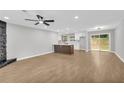 Spacious living area with wood floors, a ceiling fan, and a decorative rock fireplace feature at 1829 Herringbone Holw, Lithonia, GA 30058
