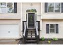 Home exterior featuring a stairway to the front door and two-car garage at 5174 Ridge Tarn, Acworth, GA 30102
