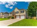 Two-story house with a well-kept lawn, brick details and a two-car garage at 5452 Sweetsprings, Powder Springs, GA 30127