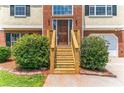 Close-up of the front door and wooden steps, surrounded by lush bushes at 5452 Sweetsprings, Powder Springs, GA 30127