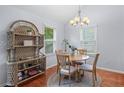 Bright dining area with natural light, featuring a round table, four chairs, and a decorative wicker shelf at 732 S Fairfield Dr, Peachtree City, GA 30269