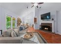 Inviting living room featuring vaulted ceiling, hardwood floors, fireplace, and a comfortable sectional sofa at 732 S Fairfield Dr, Peachtree City, GA 30269