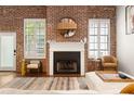 Living room with fireplace, exposed brick, wood floors, modern furniture, and decor at 320 Martin Luther King Jr Se Dr # 15, Atlanta, GA 30312