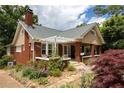 Well-maintained home with brick accents, a charming front porch, and lush landscaping at 492 Clifton Ne Rd, Atlanta, GA 30307