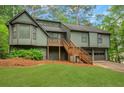 Split-level home with an olive exterior, deck, two-car garage, and green lawn at 4788 Rock Island Nw Ln, Acworth, GA 30102