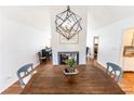 Inviting dining area with a large wooden table, modern chandelier, and view of the cozy fireplace at 150 Newton Ridge Dr, Covington, GA 30014