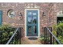 Close-up of a beautiful teal front door with a brick exterior, framed by elegant lanterns at 1534 September Chase, Decatur, GA 30033