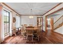 Bright dining room with hardwood floors, large windows, and a classic chandelier over the dining table at 110 The Farm Rd, Mcdonough, GA 30252