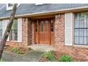 Close-up view of a stylish front door with decorative glass inserts, flanked by sidelights and white shutters at 110 The Farm Rd, Mcdonough, GA 30252