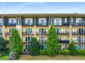 Multi-story condo building featuring private balconies, lush landscaping, and a well-maintained lawn at 1195 Milton Ter # 1304, Atlanta, GA 30315
