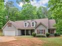 Charming single-Gathering home with gray siding, red shutters, attached garage, and a well-manicured front lawn at 445 Royal St, Mcdonough, GA 30253