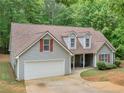 Charming single-Gathering home with gray siding, red shutters, attached garage, and a well-manicured front lawn at 445 Royal St, Mcdonough, GA 30253
