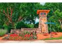 Stone entrance to the community is beautifully landscaped with flower beds at 6084 Queens River Dr, Mableton, GA 30126