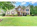 Inviting brick two story home with manicured lawn and beautiful, colorful landscaping at 9270 Colham Dr, Cumming, GA 30041