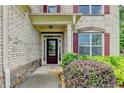 Charming brick home entrance featuring colorful landscaping and a stone walkway at 9270 Colham Dr, Cumming, GA 30041