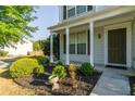 Inviting front porch with landscaped garden and well-maintained lawn at 312 Burdock Trce, Woodstock, GA 30188