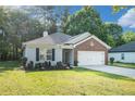 Well-maintained single-story home with a brick accent, green lawn, and an attached two-car garage at 5527 Jerome Rd, College Park, GA 30349