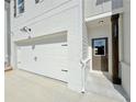 Townhome with white brick, dark trim, two car garage and covered entryway at 1277 Fern Ridge Ct # 22, Norcross, GA 30093