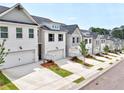 Row of townhomes featuring a two-car garage, neat landscaping, and a modern white brick facade at 1277 Fern Ridge Ct # 22, Norcross, GA 30093