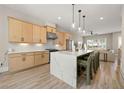Bright kitchen features large island with seating, modern appliances, stylish pendant lighting, and natural wood cabinets at 1358 Pavilion Se Ct, Atlanta, GA 30316