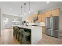 A modern kitchen featuring a waterfall island, pendant lights, stainless steel appliances, and sleek wooden cabinets at 1358 Pavilion Se Ct, Atlanta, GA 30316